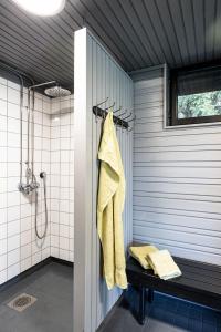 a bathroom with a shower with a yellow towel at Guesthouse Solbacka Iittala in Hämeenlinna