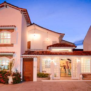a white house with a porch and a patio at La Maison de Vacances in Búzios