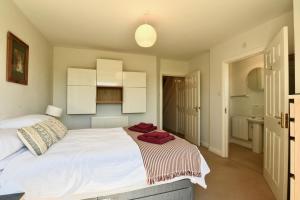 Un dormitorio con una cama blanca con una toalla. en Whole house, easy walk to town centre, Parking, Self Catering, Great View, 3 bedrooms, sleeps 6 en Stratford-upon-Avon