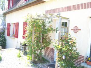 an open door to a house with a plant at Les Blancarts in Hautebut +16 photos