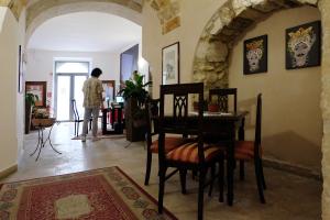 a dining room with a table and chairs in a room at Nuova Mastrarua Rooms in Syracuse