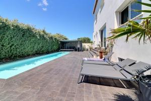 a patio with two lounge chairs and a swimming pool at Villa Design le Crès in Le Crès