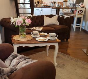 una sala de estar con una mesa de centro con flores. en Sunrise Cottage, en Mégrit