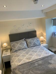 a bedroom with a bed and a night stand at Black Bull with Rooms in Cumbernauld