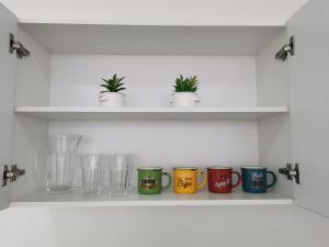 a shelf with different colored cups and vases on it at Loft Estancia Real in Morelia