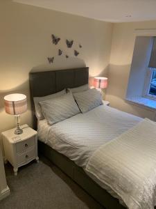 a bedroom with a bed and a lamp at Black Bull with Rooms in Cumbernauld