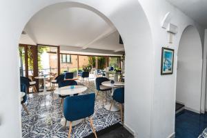 een kamer met tafels en stoelen en een muur bij Palazzo Vingius in Minori