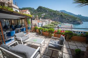 a balcony with chairs and a view of the water at Palazzo Vingius in Minori