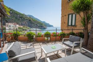 a patio with chairs and a table and a view of the ocean at Palazzo Vingius in Minori