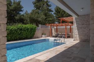 a swimming pool in a backyard with a pergola at Villa Anouk in Pitve