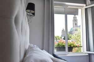 シャルトルにあるHôtel Le Boeuf Couronné Chartres - Logis Hotelsのベッドルーム1室(建物の景色を望む窓付)