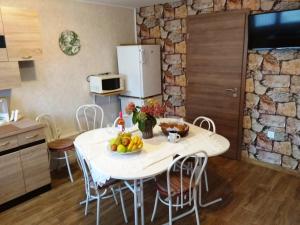 a kitchen with a table with a bowl of fruit on it at Tulipán Apartmanház in Bük
