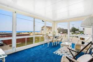 a large screened in porch with a table and chairs at Coastal Sun and Fun in Oceano