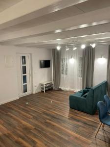 a living room with a green couch and a television at Cabana The Lux in Beclean