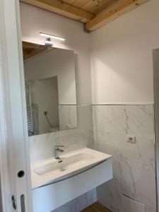 a white bathroom with a sink and a mirror at La Casa del Dottore in Rapolla