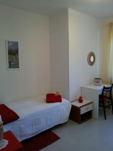 a white bedroom with a bed and a table at Agriturismo Persichitti in Torricella Peligna