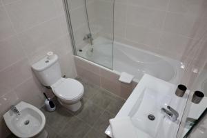a bathroom with a toilet and a sink and a tub at Villas Quinta da Lapa by AnaLodges in Câmara de Lobos +208 photos