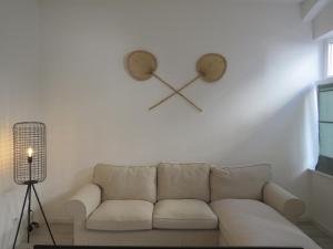 a living room with a white couch and a clock on the wall at L8 Street - Mannheim Innenstadt in Mannheim