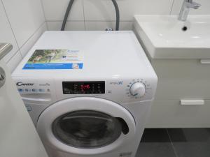 a washing machine in a bathroom with a sink at L8 Street - Mannheim Innenstadt in Mannheim +3 photos