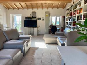 a living room with couches and a flat screen tv at Ostello La Salana in Capannori