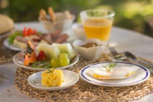 una mesa con platos de comida y un vaso de jugo de naranja en Bela Vista Hotel Boutique, en Caraíva