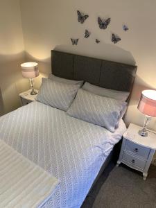 a bedroom with a bed with butterflies on the wall at Black Bull with Rooms in Cumbernauld