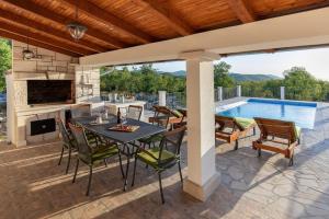 a patio with a table and chairs and a pool at Villa Menalo in Neum