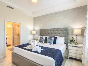 - une chambre dotée d'un grand lit avec des oreillers bleus et blancs dans l'établissement Terrific Thematic Lakeview 2B with 2 Clubhouses, à Kissimmee