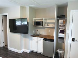 滑铁卢ENTIRE BACHELOR UNIT EN-SUITE UPTOWN WATERLOO - e5的厨房里有水槽，墙上有电视