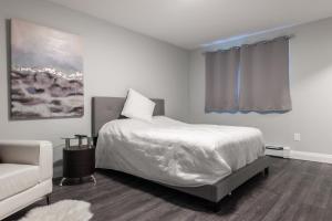 滑铁卢ENTIRE BACHELOR UNIT EN-SUITE UPTOWN WATERLOO - e5的一间带床和沙发的白色卧室