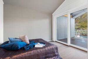 a bedroom with a bed and a large window at Gjermundsøya Brygge in Ballstad