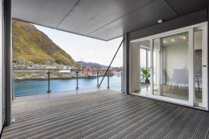 a balcony of a house with a view of the water at Gjermundsøya Brygge in Ballstad