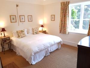 a bedroom with a white bed and a window at Cambus O' May Hotel in Ballater