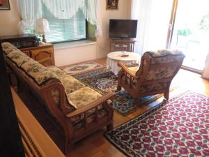 ein Wohnzimmer mit einem Sofa und einem Stuhl in der Unterkunft Bungalow Möwe in Pörtschach am Wörthersee