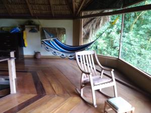 a rocking chair in a room with a hammock at Finca del Sol Eco Lodge in Santa Cruz