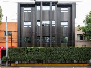 a tall building with a hedge in front of it at Hotel Vista Alegre in Mexico City