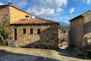 a stone house with a roof on a street at Maison typique corse à 10 min d'Ajaccio et plages in Alata