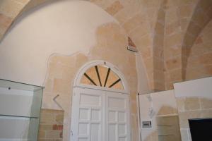 a white door in a room with a stone wall at Depandance Economy in Manduria