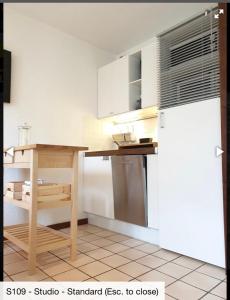 a kitchen with a wooden table and a refrigerator at Studio 4 personnes RDC avec jardin et parking sous terrain in Samoëns +8 photos
