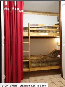 um quarto com 2 beliches e uma cortina vermelha em Studio 4 personnes em Samoëns