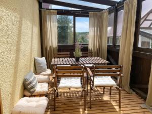 a screened in porch with a table and chairs at Ferienwohnung Ava - Heiligkreuztal in Heiligkreuztal