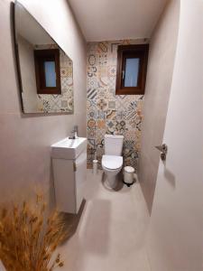 a bathroom with a toilet and a sink and a mirror at BELLE VUE Mountain Home in Kalopanayiotis