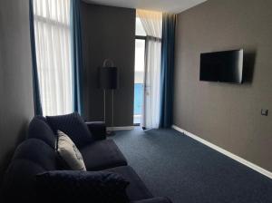 un soggiorno con divano e TV a schermo piatto di Pano Hotel a Gonio