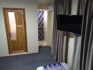 a room with a television and a door with a curtain at Samarqand Standart in Samarkand