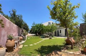 un patio con plantas y una casa en Maria`s Peaceful Nest, en La Canea