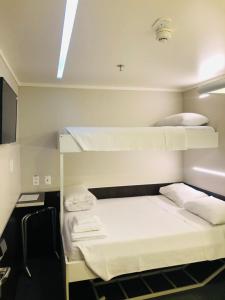 a room with two bunk beds and a tv at Hotel Aero Sleep Campinas in Campinas