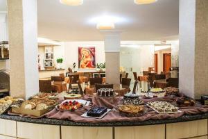a buffet of food on a table in a room at Diaudi Hotel in São José