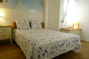 a bedroom with a blue and white bed and a window at Fragata Beach Seaview in Sitges