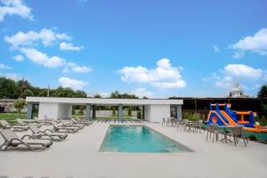 a patio with chairs and a pool and a playground at Підгорецький маєток - готель in Pidhirtsi +102 photos