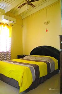 a bedroom with a bed with a yellow and brown blanket at Over The Hill Residence in Saint Martin